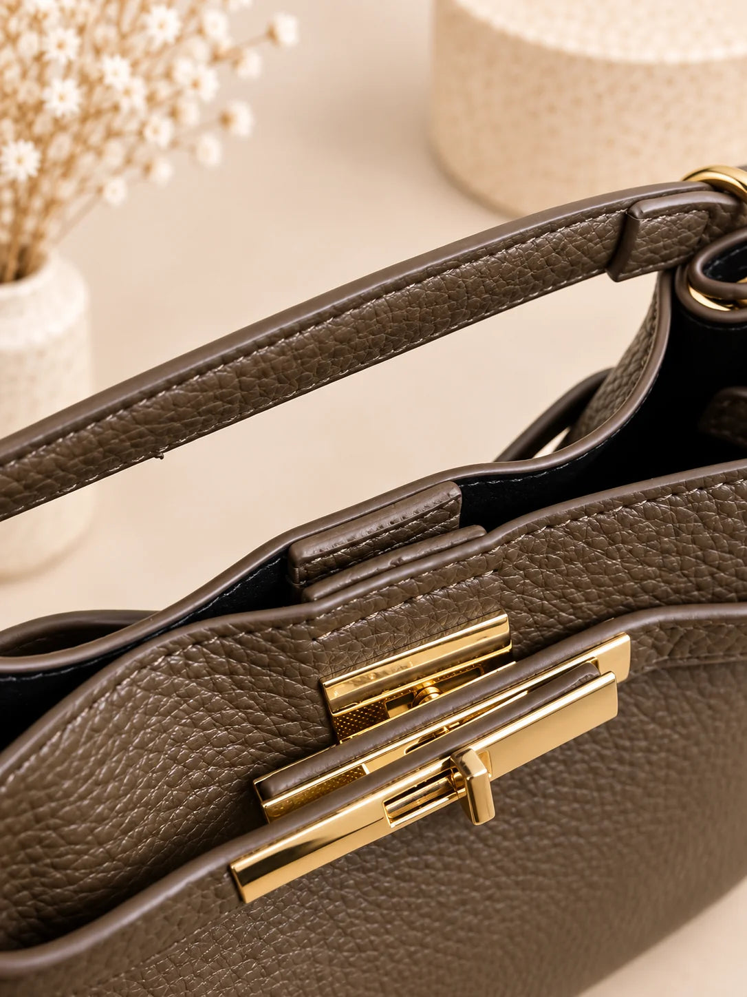 Pormenor do fecho dourado e da asa da bolsa Éclat verde azeitona