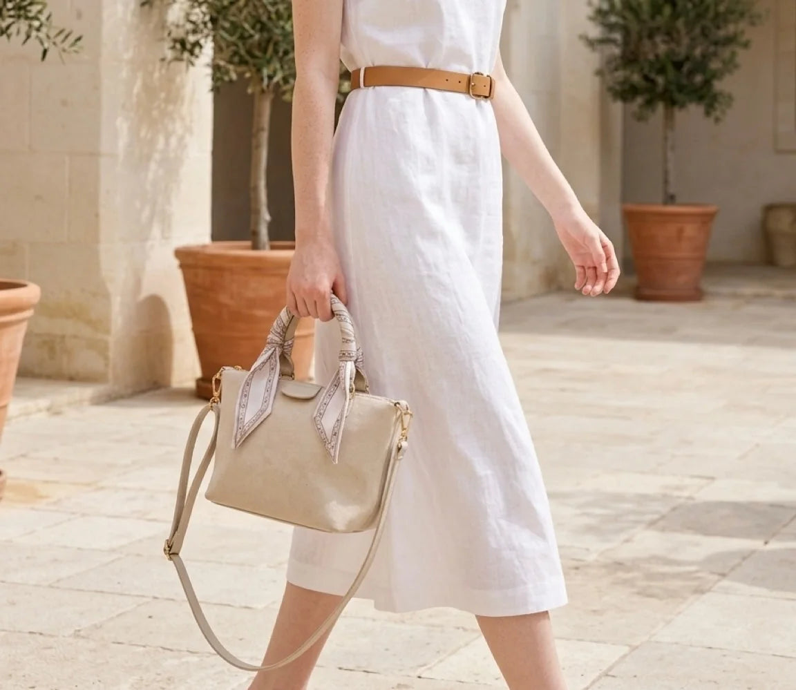 Mulher de vestido branco com bolsa Mia bege e lenço de seda