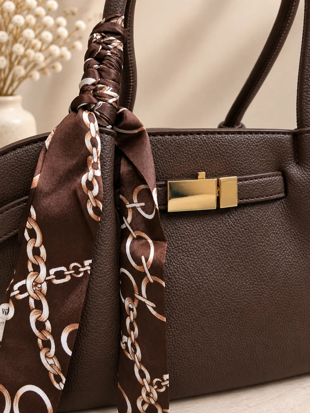 Pormenor do fecho dourado e lenço de seda da bolsa Velvet castanho escuro